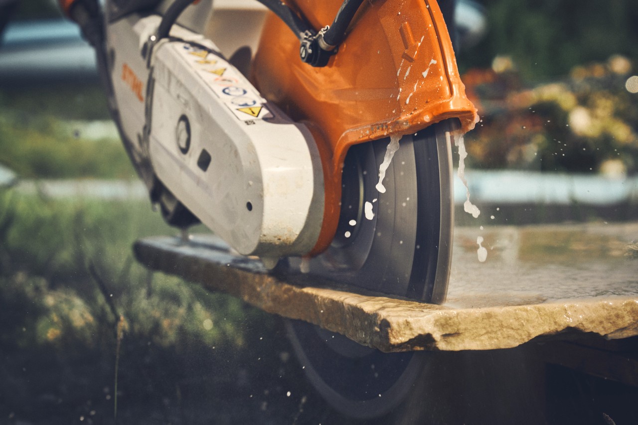 Lähikuvassa katulaattojen leikkaaminen STIHL TSA 300 -akkukäyttöisellä katkaisuhiomakoneella.  BU: TSA 300 tarjoaa tarkkuutta ja suurta leikkuutehoa. 