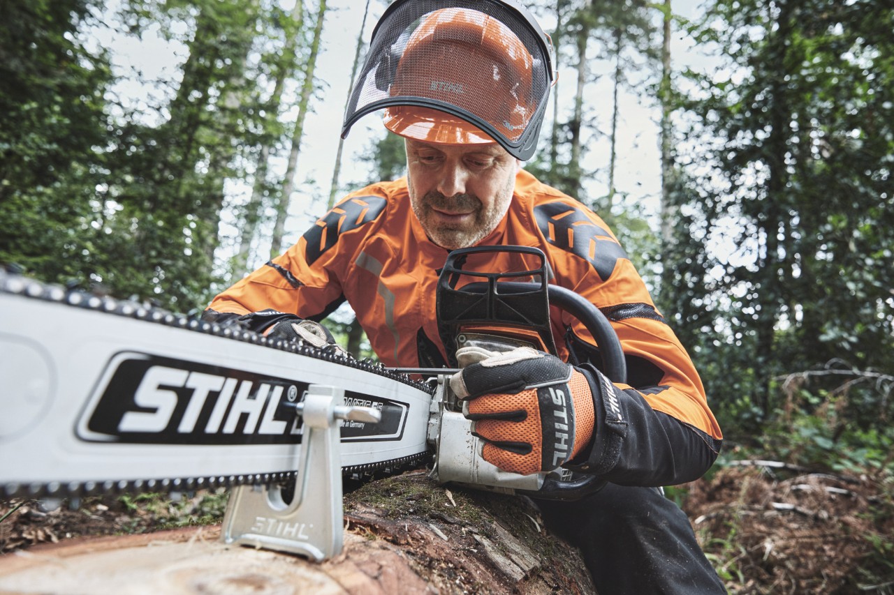 Suojavarusteita käyttävä mies työskentelemässä STIHL-moottorisahalla metsässä