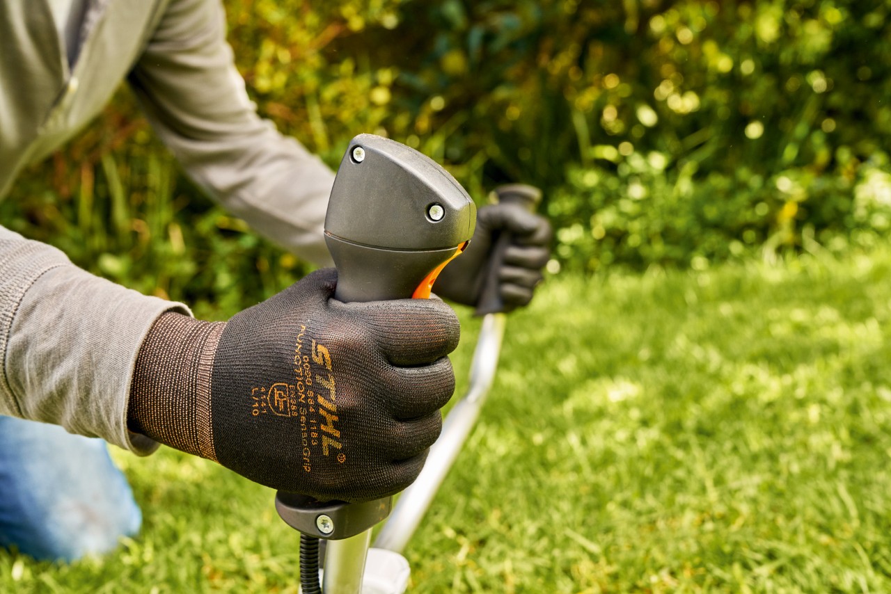Mies käynnistämässä bensiinikäyttöisen STIHL FS 91 -raivaussahan moottoria