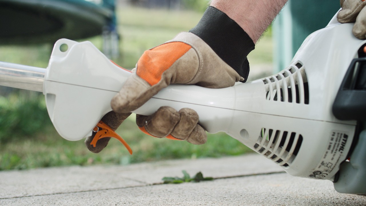 Bensiinikäyttöisen STIHL FS 38 -raivaussahan kaasuvivun painaminen