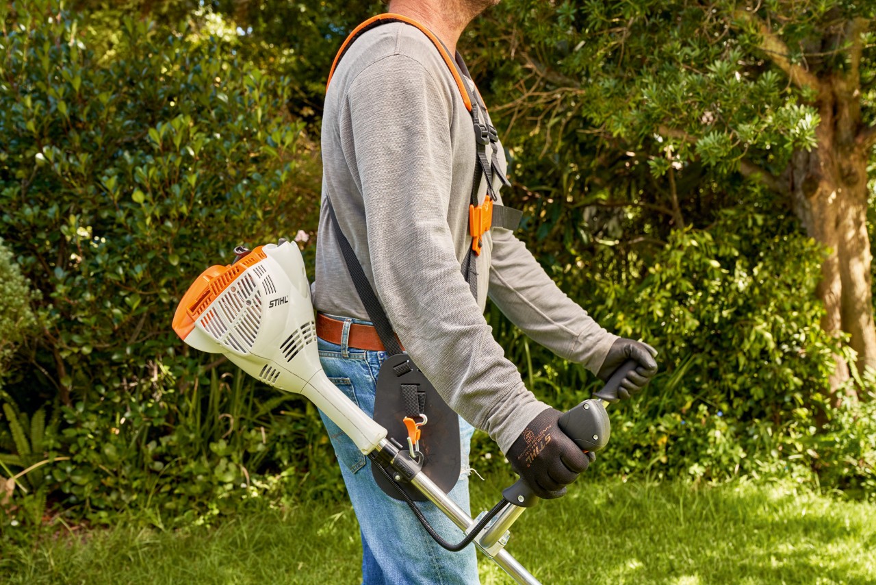 Mies nostamassa bensiinikäyttöistä STIHL FS 56 -raivaussahaa maasta