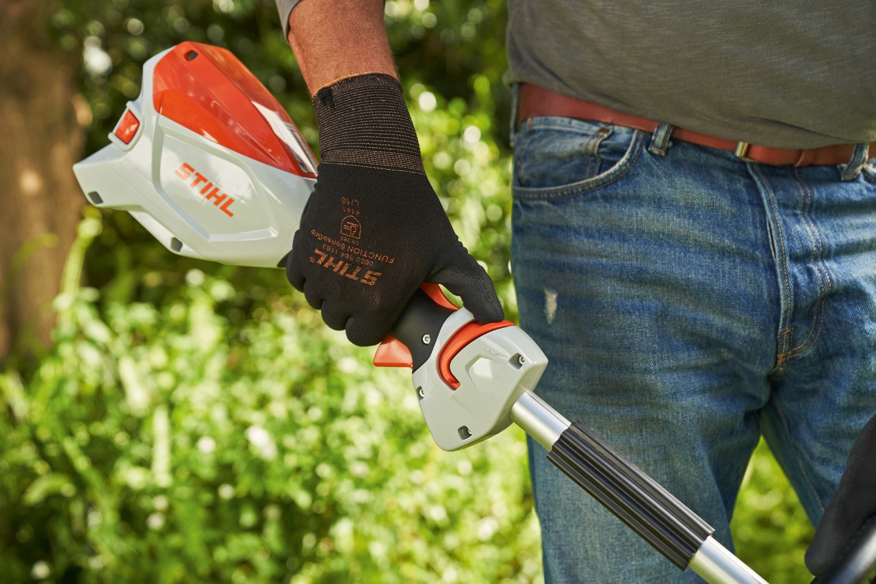 Suojakäsineitä käyttävä mies työntämässä akkukäyttöisen STIHL FSA 60 -raivaussahan vapautusliukusäädintä silmukkakahvaa kohti