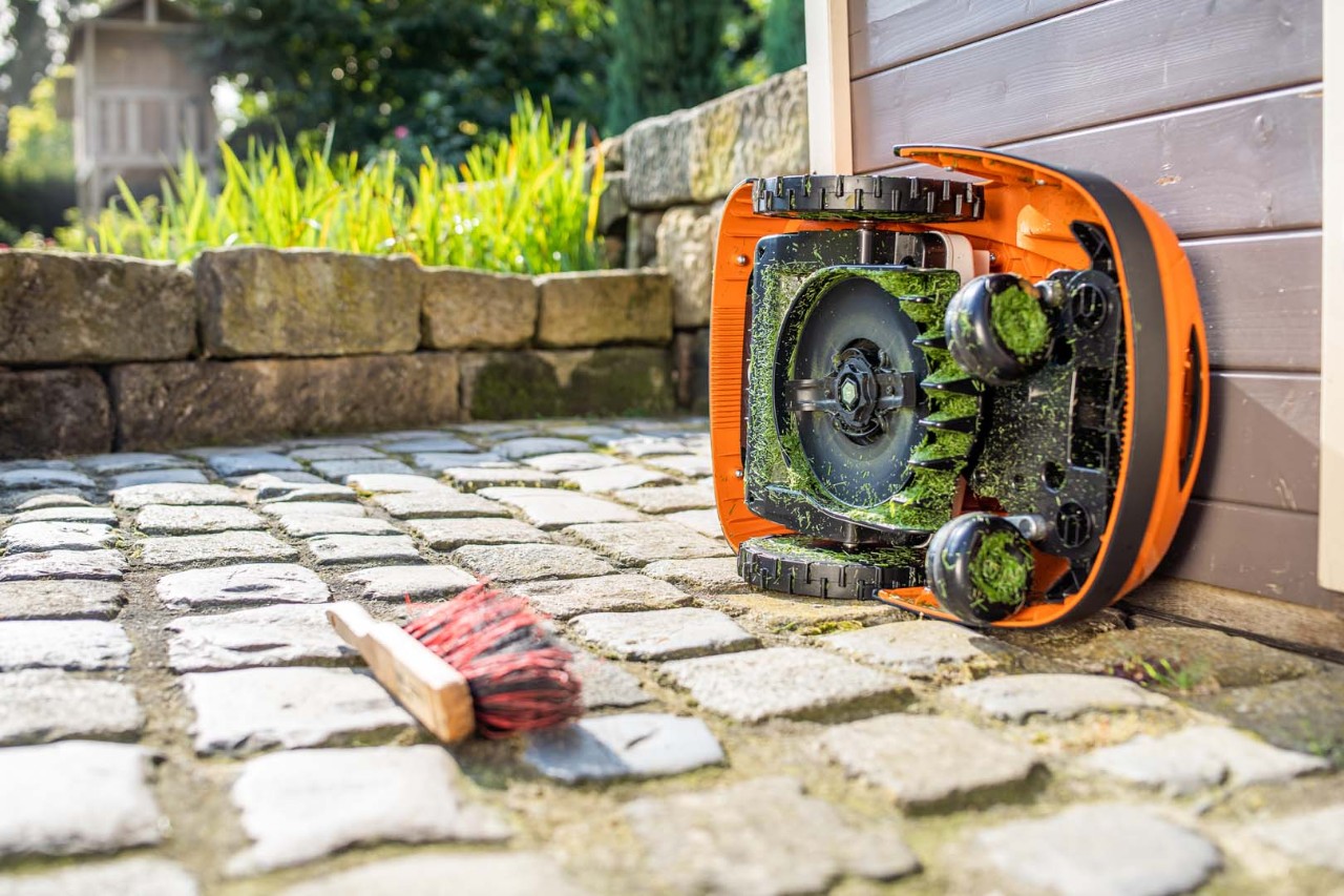 STIHL iMOW® -robottiruohonleikkuri kallistettuna kyljelleen puhdistusta varten