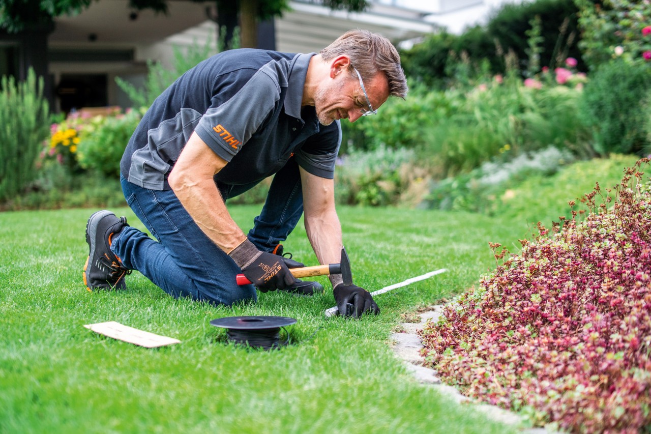 STIHL-jälleenmyyjä asentamassa rajakaapelia.