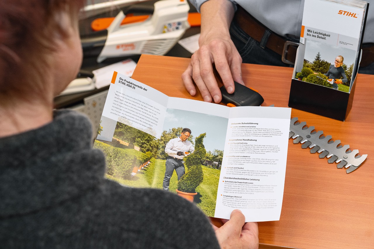 Esitteestä STIHL HSA 25 -tuotteen eduista lukeva henkilö